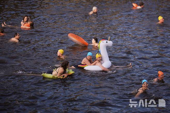 [베를린=AP/뉴시스] 17일(현지 시간) 독일 베를린 슈프레강에서 시민들이 수영 금지 해제를 촉구하며 수영하고 있다. 슈프레강은 수질 오염에 따른 보건 위험으로 100년 넘게 수영이 금지됐으며 강물과 분리된 부유식 수영장만 운영되고 있다. 시민 주도 비영리단체 '플루스바트 베를린'은 슈프레강이 수영할 만큼 수질이 개선됐다면서 수영 허용을 촉구하고 있다. 2025.06.18.