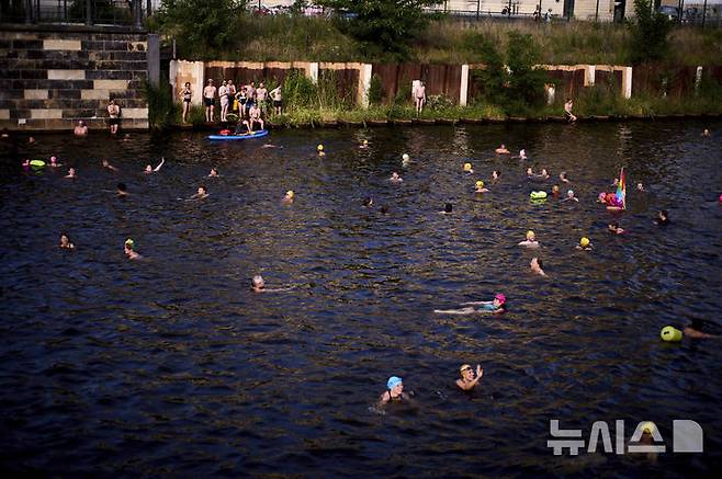[베를린=AP/뉴시스] 17일(현지 시간) 독일 베를린 슈프레강에서 시민들이 수영 금지 해제를 촉구하며 수영하고 있다. 슈프레강은 수질 오염에 따른 보건 위험으로 100년 넘게 수영이 금지됐으며 강물과 분리된 부유식 수영장만 운영되고 있다. 시민 주도 비영리단체 '플루스바트 베를린'은 슈프레강이 수영할 만큼 수질이 개선됐다면서 수영 허용을 촉구하고 있다. 2025.06.18.
