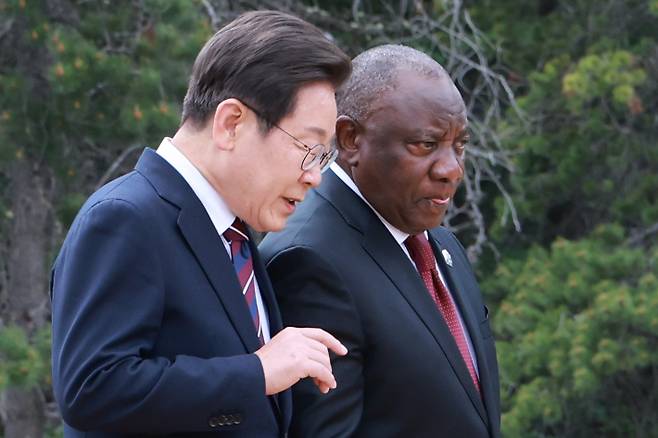 이재명 대통령과 시릴 라마포사 남아프리카공화국 대통령이 17일(현지시간) 캐나다 앨버타주 캐내내스키스 주요 7개국(G7) 정상회의장에서 G7 및 초청국 기념촬영을 위해 이동하며 대화하고 있다. 연합뉴스
