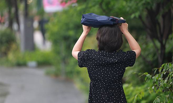 전국 곳곳에 비가 내린 지난 16일 서울 광화문광장 인근에서 시민이 가방으로 비를 막으며 이동하고 있다. 연합뉴스