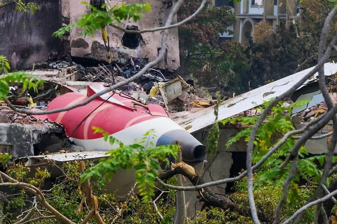 14일(현지시간) 인도 아메다바드 공항 인근 주거지역에서 크레인이 6월 12일 발생한 인도항공 171편 추락 사고의 잔해 속에서 항공기 꼬리 부분을 제거하고 있다. 조사관들은 런던행 여객기가 인도 아메다바드 시의 주거지역으로 추락해 탑승자 및 지상에 있던 최소 265명이 사망한 사고 현장에서, 6월 13일 블랙박스 기록 장치를 회수했다.(사진=AFP)