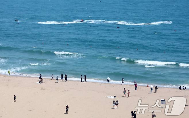 절기상 하지(夏至)를 사흘 앞둔 18일 오후 부산 해운대해수욕장을 찾은 시민, 관광객들이 해변가를 거닐며 더위를 식히고 있다. 2025.6.18/뉴스1 ⓒ News1 윤일지 기자