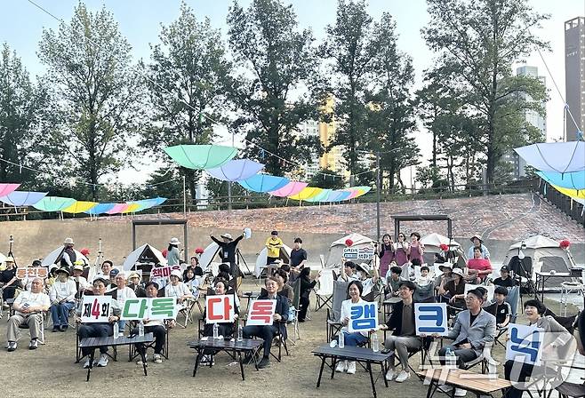 광주 서구 동천동이 지난 18일 동천동 유적근린공원에서 '제4회 동천동 다독다독 캠크닉'을 개최한 뒤 기념촬영하고 있다. (광주 서구 동천동 제공. 재판매 및 DB금지) 2025.6.19/뉴스1