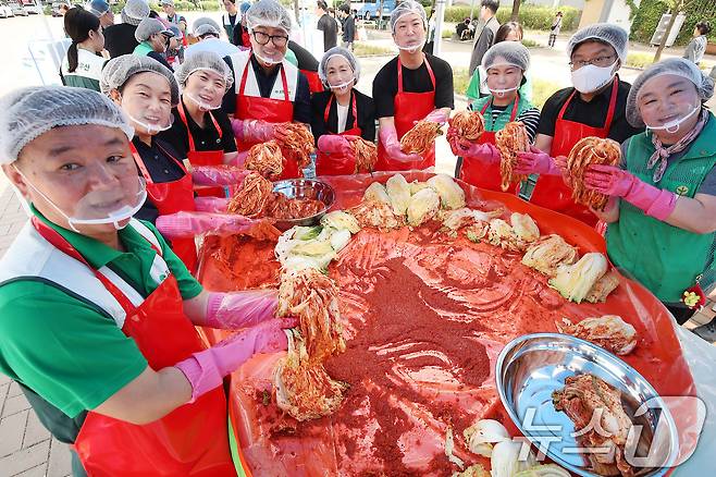 19일 대구 동구 율하체육공원에서 열린 '초록우산이 펼치는 초능력 김치 나눔'에 참여한 봉사자들이 정성껏 버무린 김치를 들어 보이고 있다. 2025.6.19/뉴스1 ⓒ News1 공정식 기자