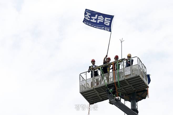 김형수 금속노조 거제통영고성조선하청지회장이 19일 고공농성을 벌이던 철탑에서 내려오며 금속노조 깃발을 흔들고 있다. 문재원 기자