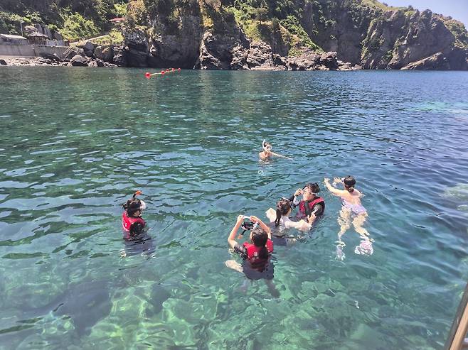 Travelers swim during a package tour by travel agency Jigu-noriter. [JIGU-NORITER]