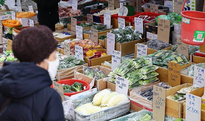 서울 시내 한 전통시장에서 한 시민이 농산물을 살펴보고 있다. [사진 = 연합뉴스]