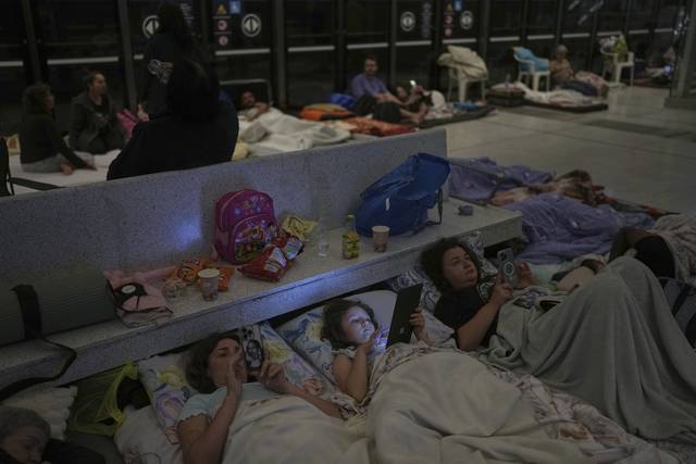 17일 이란과 이스라엘간 분쟁이 계속되며 이스라엘 시민들이 텔아비브 인근 라마트 간의 지하철역에 마련된 대피소에 누워 스마트폰을 들여다보고 있다. AP 연합뉴스