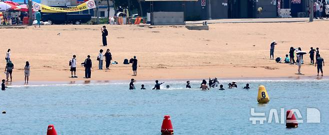 [인천=뉴시스] 전진환 기자 = 전국이 30도 안팎의 무더운 날씨를 보인 19일 인천 중구 을왕리해수욕장을 찾은 시민들이 바닷물에 몸을 담근채 더위를 식히고 있다. 2025.06.19. amin2@newsis.com