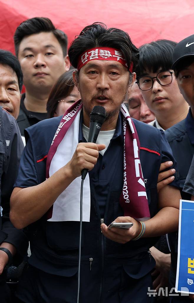 [서울=뉴시스] 배훈식 기자 = 김형수 거통고 조선하청지회장이 19일 오후 서울 중구 한화빌딩 앞에서 97일 만에 고공농성을 해제하고 지상에 내려와 조합원들과 함께 기자회견을 하고 있다. 2025.06.19. dahora83@newsis.com