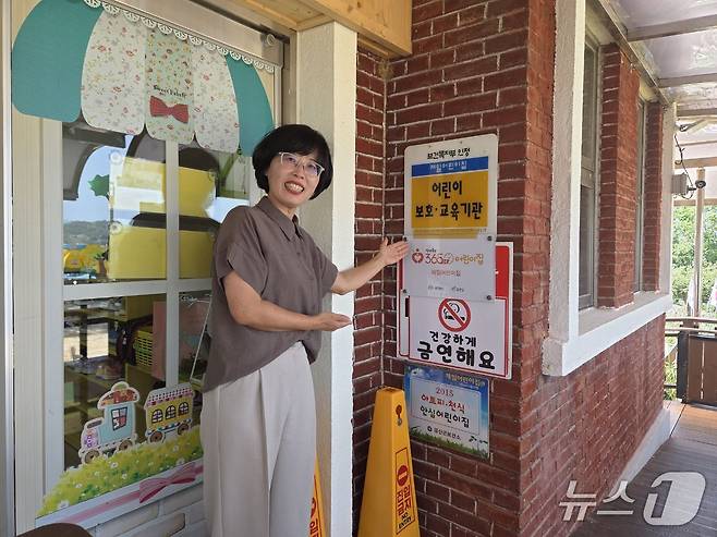 곽영주 제일어린이집 원장이 365x24 어린이집 현판 앞에서 기념사진을 찍고 있다. (금산군 제공.재판매 및 DB 금지)/뉴스1