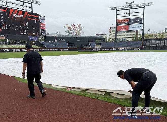 그라운드 관리팀 직원들이 경기장을 살피고 있다.
