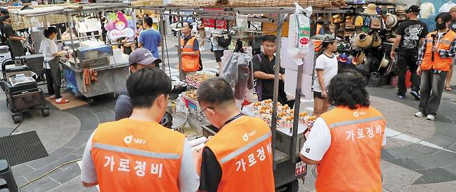 19일 오후 서울 중구 명동 거리에서 중구 단속반이 노점을 점검하고 있다. 단속반은 노점들이 카드 단말기를 설치했는지, 격일제 운영 규칙을 지키고 있는지 등을 확인했다. /박성원 기자