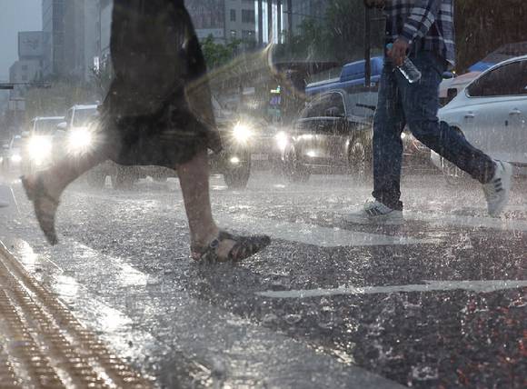 갑작스런 폭우가 내린 가운데 서울 종로구 광화문광장 인근에서 시민들이 이동하고 있다. [사진=연합뉴스]