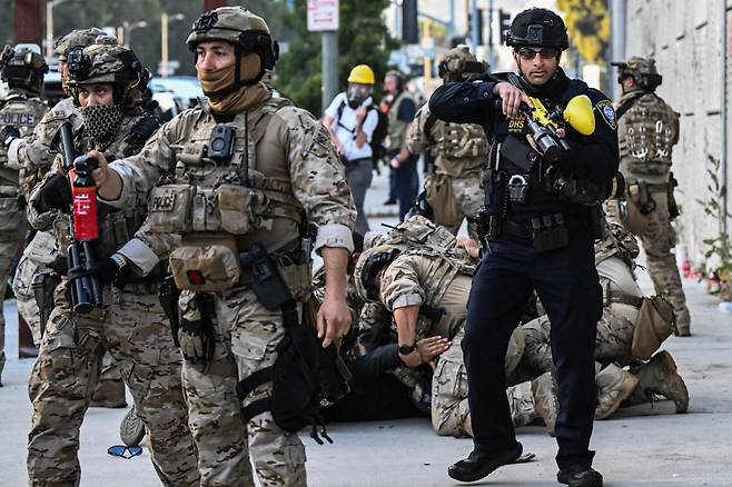 지난 12일(현지시간) 미국 로스앤젤레스 도심에서 열린 불법이민 단속 항의 시위 참가자가 체포되고 있다. 사진=AFP(연합뉴스)