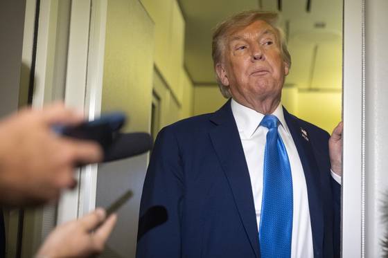 U.S. President Donald Trump speaks with reporters while flying aboard Air Force One en route from Calgary, Alberta, on June 16. [AP/YONHAP]