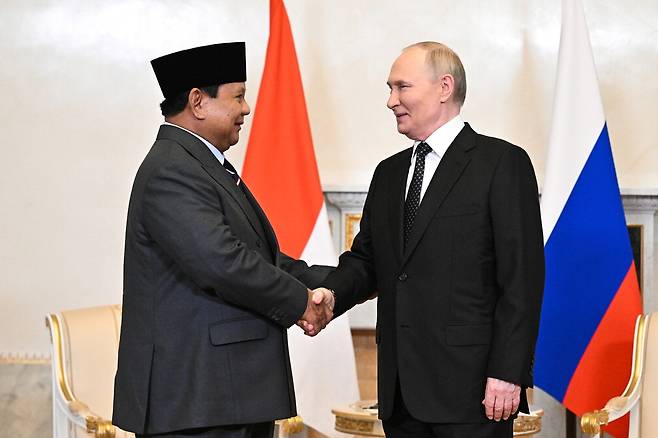 블라디미르 푸틴 러시아 대통령(오른쪽)과 프라보워 수비안토 인도네시아 대통령이 19일(현지시간) 러시아 콘스탄틴 궁전에서 열린 정상회담에서 악수를 하고 있다.  타스통신연합뉴스