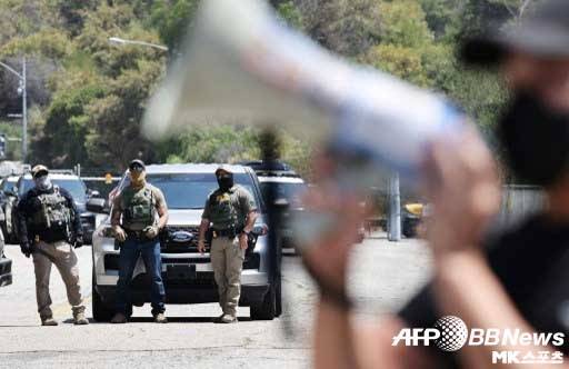 ICE 요원들이 다저스타디움 입구에서 시위대의 모습을 지켜보고 있다. 사진(美 로스앤젤레스)=ⓒAFPBBNews = News1