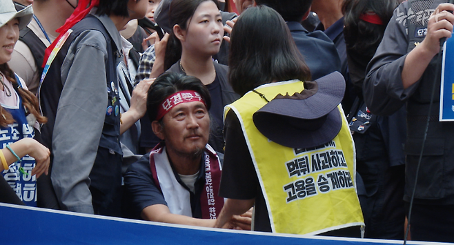 김형수 거제통영고성 조선하청지회 지회장이 고공농성을 이어가고 있는 한국옵티칼하이테크 노조의 이지영 사무장에게 미안함을 표하고 있다