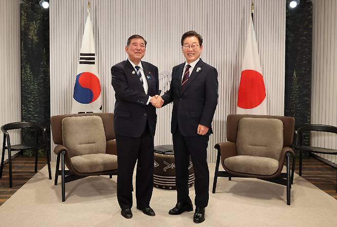 이재명 대통령이 17일(현지시간) 캐나다 앨버타주 캐내내스키스 주요 7개국(G7) 정상회의장에서 열린 한일 정상회담에서 이시바 시게루 일본 총리와 악수하며 기념촬영을 하고 있다. 연합뉴스