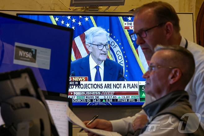 뉴욕증권거래소(NYSE) 객장에서 18일(현지시간) 제롬 파월 미국 연방준비제도(연준) 의장의 기자회견이 화면으로 중계되는 가운데 트레이더들이 업무를 보고 있다.  ⓒ 로이터=뉴스1 ⓒ News1 신기림 기자