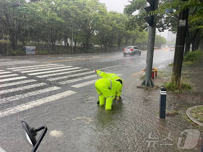 세찬 장맛비가 내리고 있는 21일 광주 광산구 관계자들이 도로 맨홀 뚜껑을 정비하고 있다. (광산구 제공. 재판매 및 DB 금지) 2025.6.21/뉴스1