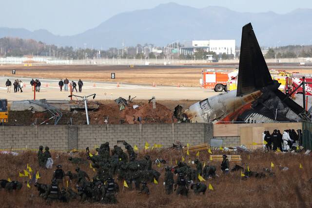 지난해 12월31일 오후 전남 무안군 무안국제공항 제주항공 참사 현장에서 미국 국가교통안전위원회(NTSB) 관계자들을 비롯한 한미합동조사단이 사고 활주로를 살펴보고 있다. 김영원 기자 forever@hani.co.kr