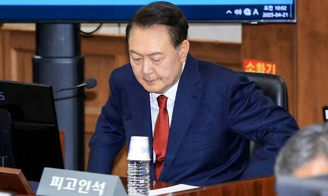 윤석열 전 대통령이 지난 4월21일 오전 서울 서초동 서울중앙지법에서 열린 내란 우두머리 혐의 형사 재판 2차 공판에 출석해 피고인석에 앉고 있다. 사진공동취재단