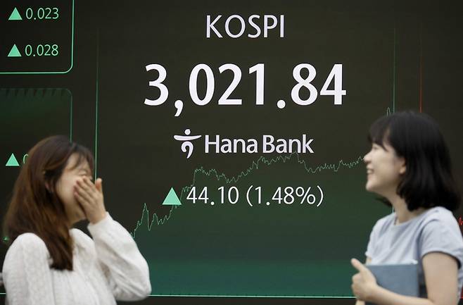 코스피지수가 3000을 넘긴 20일 서울 중구 하나은행 본점 딜링룸에서 직원들이 환한 표정을 보이고 있다. [김호영 기자]