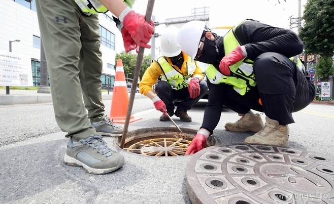 지난 17일 오전 광주 북구 용봉동 한 교차로에서 북구 하천방재과 하수팀 직원들이 추락사고를 사전 예방하기 위해 맨홀 추락방지 안전망을 점검하고 있다. 기사와 직접적인 관련 없는 자료 사진. /사진=뉴시스(광주 북구 제공).