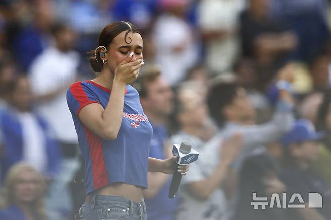 [로스앤젤레스=AP/뉴시스] 라틴 팝 가수인 네자가 15일(한국 시간) 미국 캘리포니아주 로스앤젤레스의 다저스타디움에서 벌어진 2025 메이저리그(MLB) LA 다저스와 샌프란시스코 자이언츠의 경기 전 스페인어로 미국 국가를 부른 뒤 슬픈 표정을 짓고 있다. 2025.06.15
