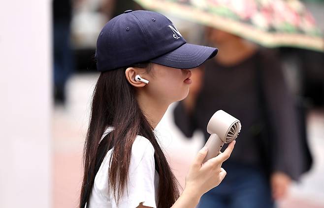 대구 중구 동성로에서 한 시민이 손 선풍기를 들고 길을 걷고 있다. 뉴시스