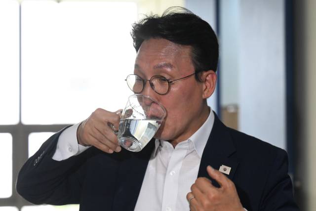 김민석 국무총리 후보자가 19일 서울 영등포구 꿈더하기 사회적협동조합에서 열리는 발달장애인 일자리 현장 간담회 장소로 이동 중 물을 마시고 있다. 조태형 기자