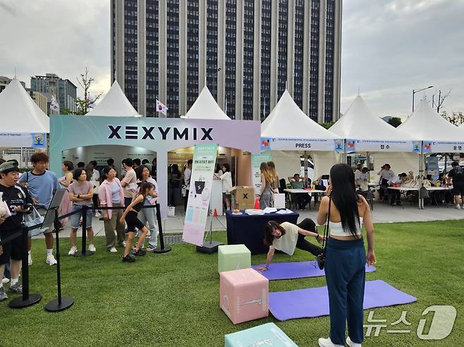 대한요가회가 UN이 국제기념일로 제정한 '세계요가의 날'을 기념해 '2025 UN 세계요가의 날' 행사를 21일 서울 광화문광장에서 열었다. 이날 국내 대표 애슬레저 기업 젝시믹스가 공식 파트너사로 참여했다. 젝시믹스 부스 전경.ⓒ 뉴스1/김진희 기자.