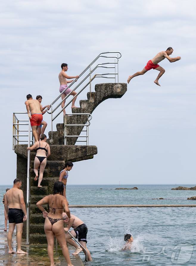 유럽 대륙에 때 이른 폭염이 찾아오며 프랑스 서부 일부 지역의 낮 최고 기온이 섭씨 38도, 체감온도는 40도를 기록한 가운데, 21일(현지시간) 프랑스 북서부 브르타뉴 지방의 생말로 해변을 찾은 시민들이 다이빙 등 해수욕을 하며 더위를 식히고 있다. 2025.6.22/뉴스1 ⓒ News1 이준성 기자
