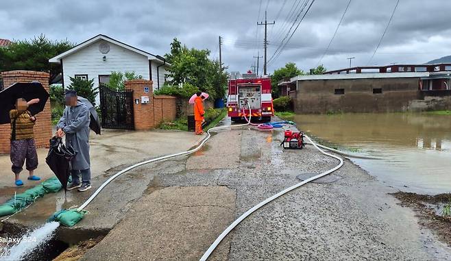 21일 거센 장맛비가 하루 종일 쏟아진 전남 담양군에서 119 소방대원들이 침수 지역에서 배수 지원을 하고 있다. /연합뉴스