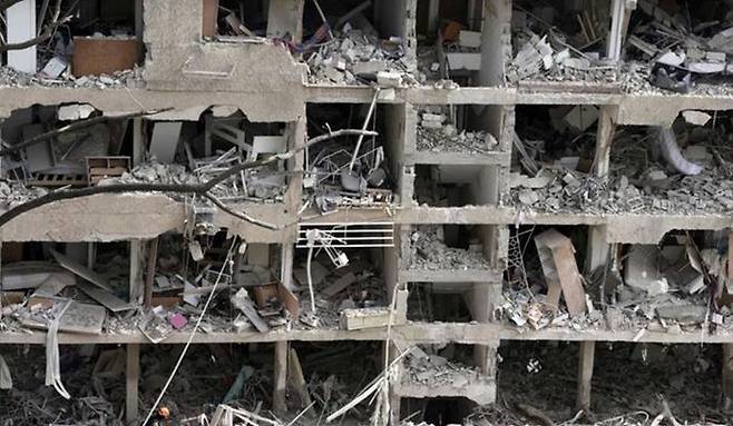 22일(현지시간) 이스라엘 수도 텔아비브에서 이란 공격으로 파괴된 건물에서 소방대원들이 구조 작업을 벌이고 있다. ⓒ AP/뉴시스