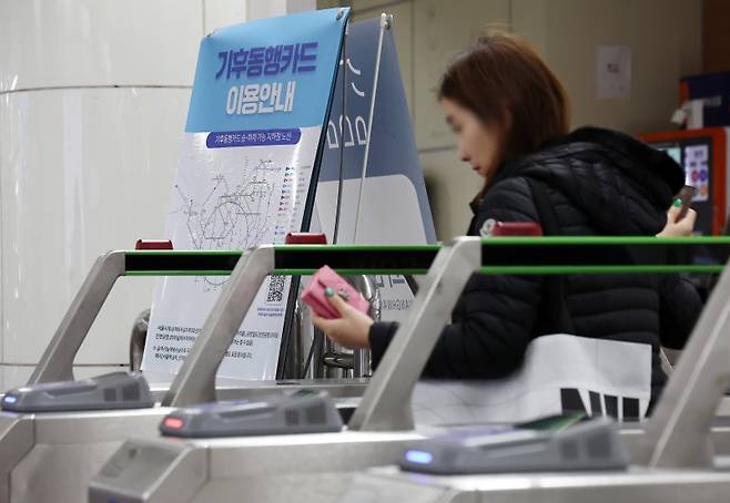 지난 4월 16일 서울 광화문역에서 기후동행카드 관련한 안내문 옆 개찰구로 시민이 지나가고 있다. 연합뉴스