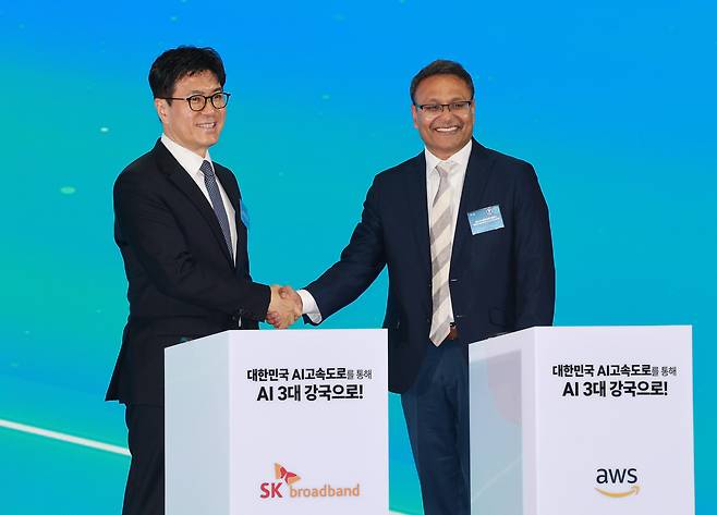 Park Jin-hyo, left, president of SK Broadband, shakes hands with Prasad Kalyanaraman, vice president of infrastructure at Amazon Web Services (AWS), after signing an agreement to build the Ulsan AI Data Center at the launch event held at the Ulsan Exhibition and Convention Center on June 20. [JOINT PRESS CORPS]