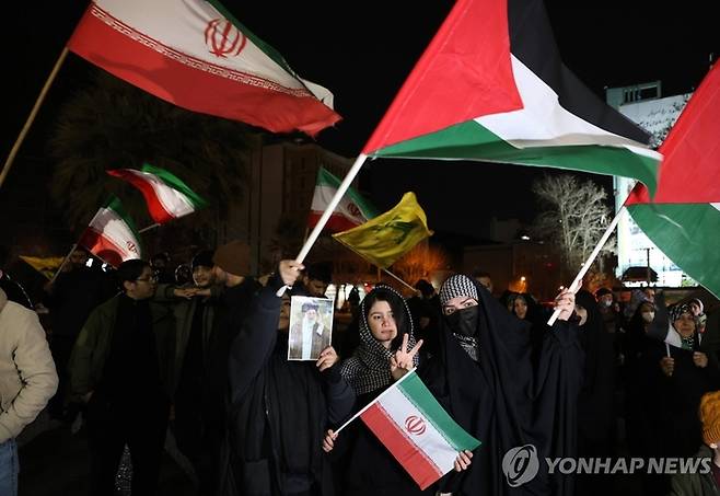 이란 테헤란의 광장에서 시민들이 팔레스타인 국기와 이란 국기를 함께 흔들고 있는 모습. EPA 연합뉴스