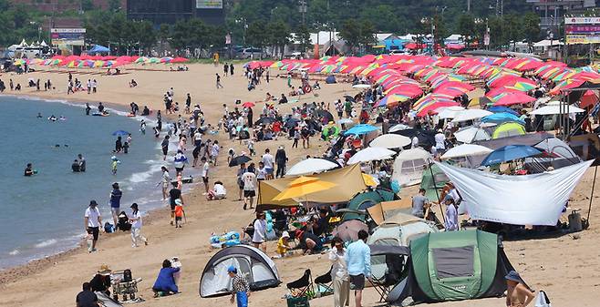 22일 인천 중구 왕산해수욕장을 찾은 시민들이 더위를 식히고 있다. [사진 = 연합뉴스]