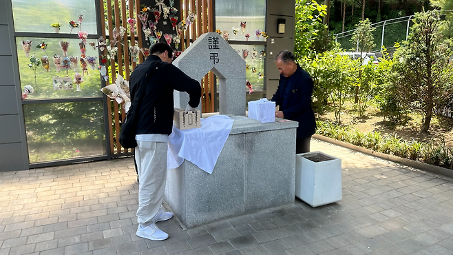 서울시립승화원에 있는 유택동산에서 자원봉사자들이 13일 장례를 치른 신모씨와 유모씨의 유골을 산골하고 있다.  경예은 기자.
