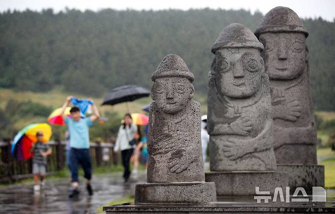 [서귀포=뉴시스] 우장호 기자 = 올해 첫 장맛비가 내리는 12일 오전 제주 서귀포시 대정읍 송악산 둘레길에서 우산을 쓴 관광객들이 걸어가고 있다. 2025.06.12. woo1223@newsis.com