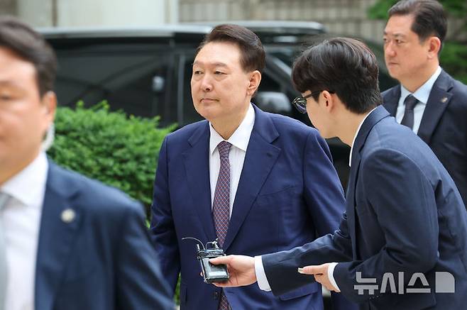 [서울=뉴시스] 사진공동취재단 = 윤석열 전 대통령이 16일 오전 서울 서초구 서울중앙지방법원에서 열린 내란 우두머리 혐의·직권남용 권리행사 방해 혐의 사건 7차 공판에 출석하며 취재진 질문을 듣고 있다. 2025.06.16. photo@newsis.com