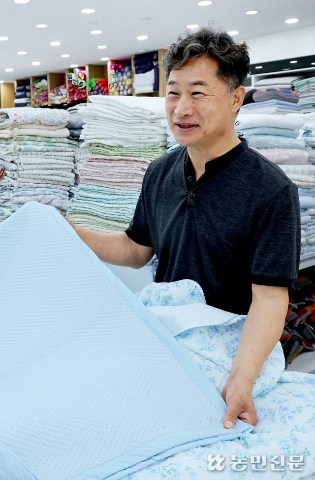 큰장길 침구류 명물거리 이불 가게 일성침장의 이형원 대표가 여름 이불에 대해 설명하고 있다.