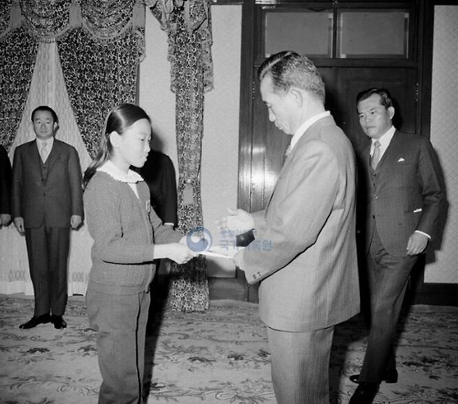 1970년대 당시 박정희 대통령이 청와대에서 초중고생한테서 방위성금을 전달받고 있다. 국가기록원
