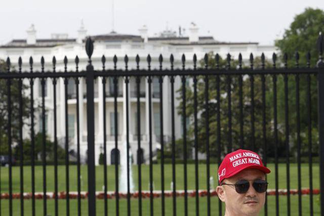 지난달 11일 미국 워싱턴 백악관 앞에 도널드 트럼프 미 대통령 선거 구호(’미국을 다시 위대하게’) 모자를 쓴 남성이 서 있다. 워싱턴=AFP 연합뉴스