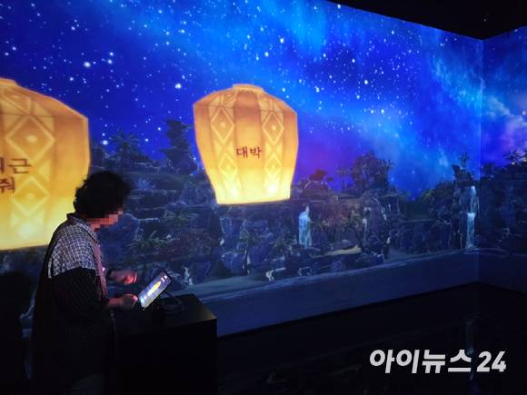 23일 서울 광진구 워커힐호텔 빛의 시어터에서 '로스트아크 미디어아트전: 빛의 여정'이 개최된 가운데, 풍등 체험 공간인 '스튜디오 룸'에서 관람객들의 소원이 담긴 풍등이 게임 내 공간인 '별모래 해변'으로 날려지고 있다. [사진=박정민 기자]