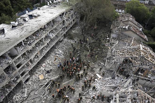 구조대원과 소방관들이 22일(현지시간) 이스라엘 텔아비브에서 이란에서 발사된 미사일 직접 공격 현장을 구조대원과 소방관들이 수습하고 있다. AP연합뉴스