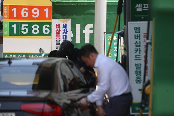 A driver fills up on fuel at a gas station in Seoul on June 23. [YONHAP]